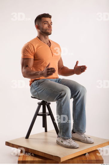 Sitting pose orange thsirt light blue jeans of bodybuilder Harold